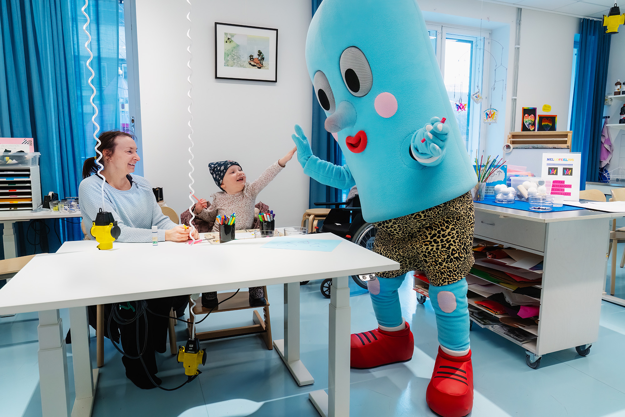 A child with the Queen Silvia's Children's hospitals mascot.