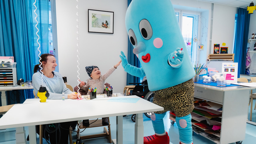 A child with the Queen Silvia's Children's hospitals mascot.