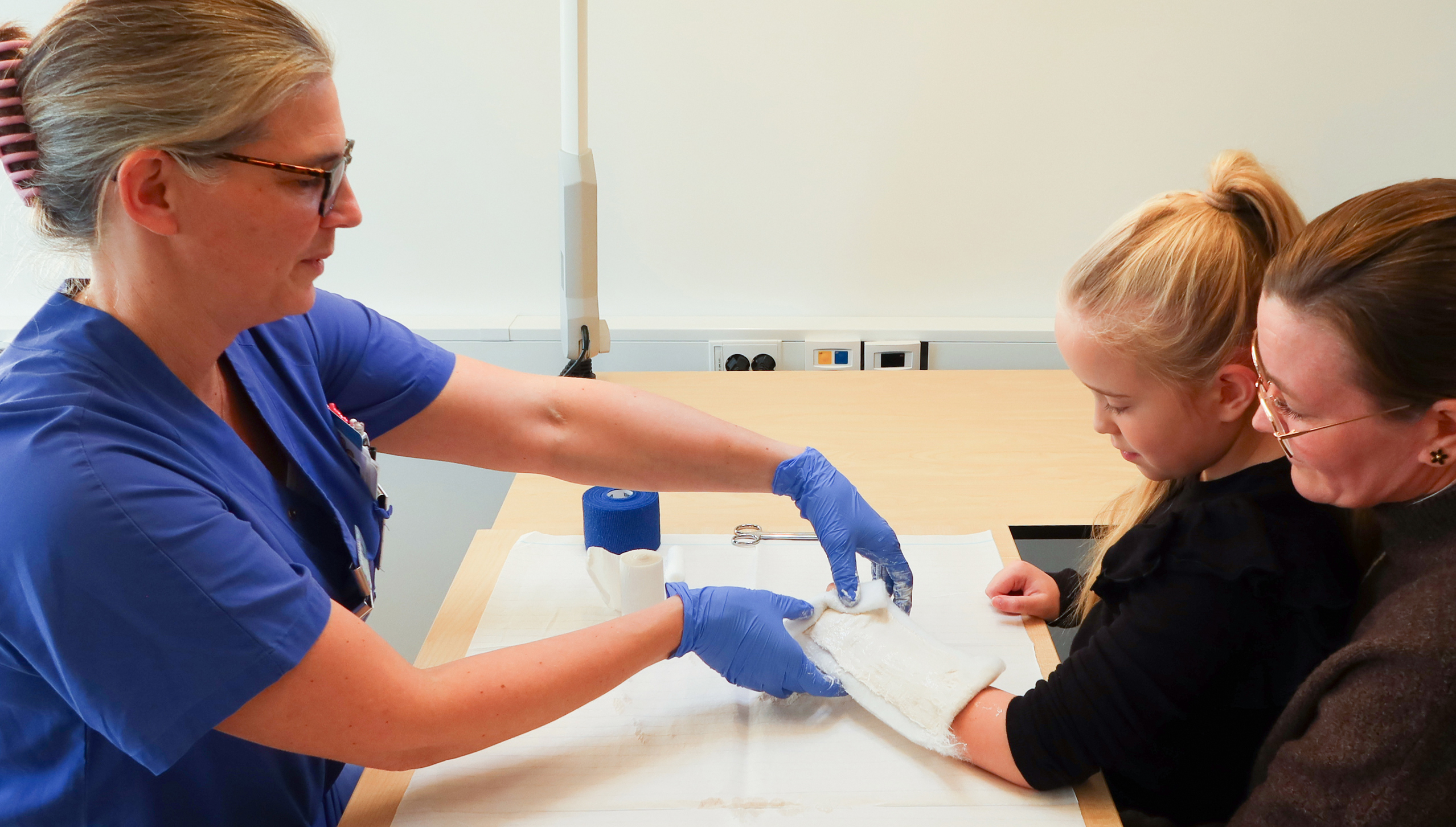 Ett barn får handen gipsad