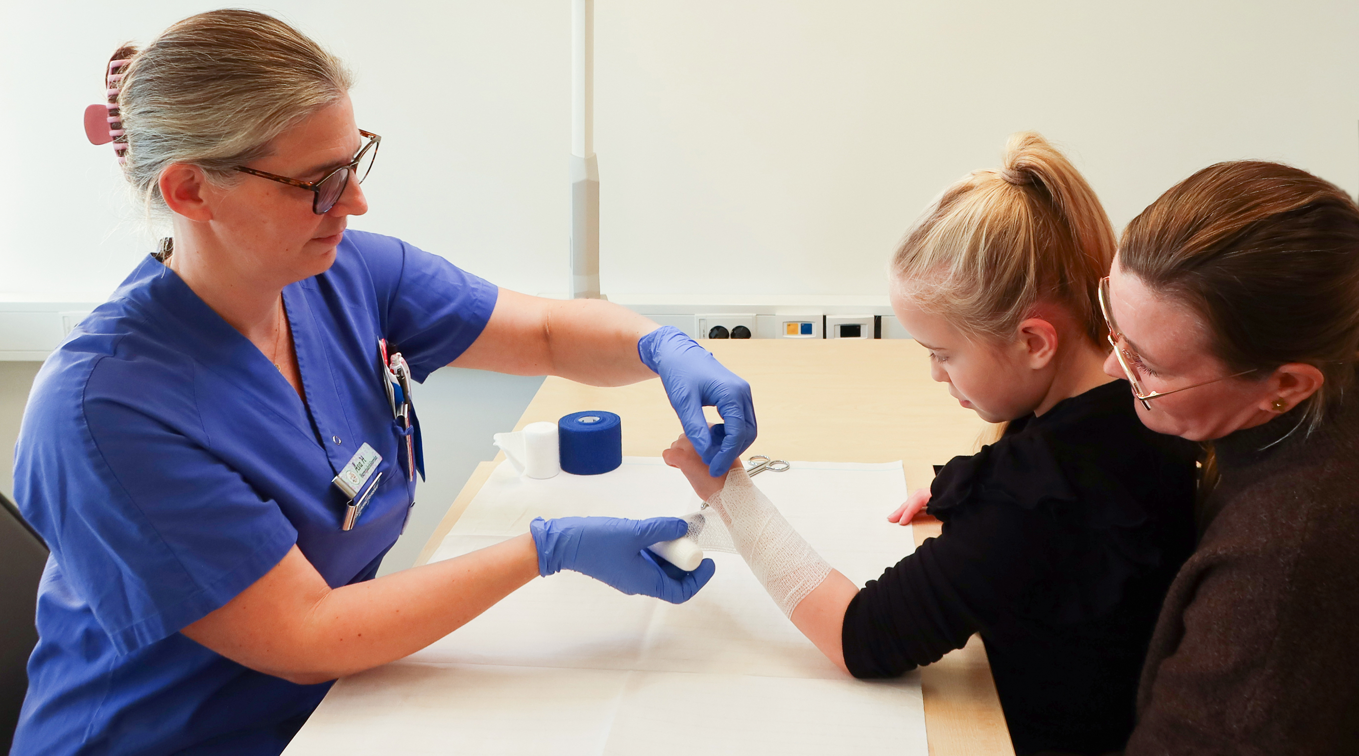 Ett barn får en gasbinda runt handen