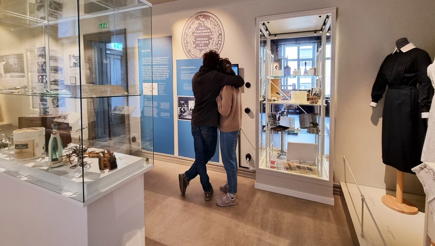 Ett par håller om varandra och tittar på en utställning på muséet
