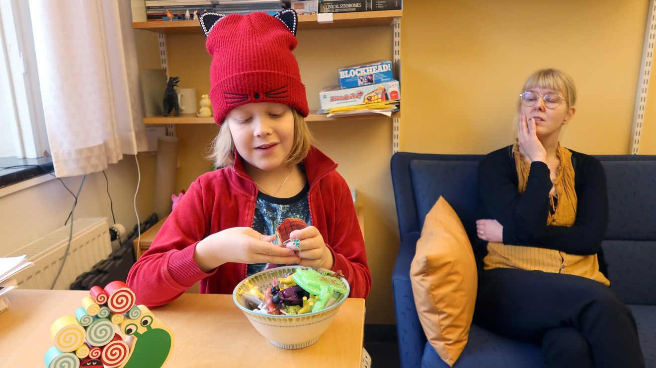 Ett barn väljer en liten leksak ur en skål