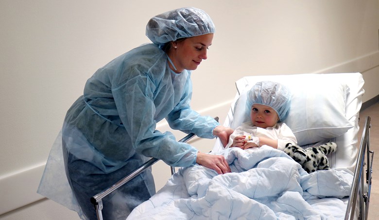 Ett barn och en mamma med operationskläder