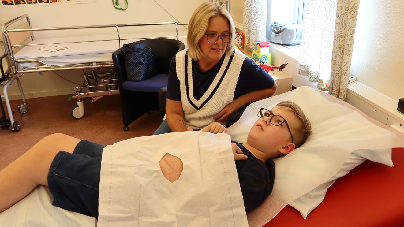 Ett barn med en vit duk på magen