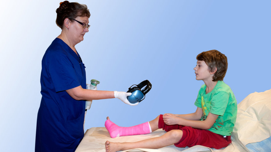 Ett barn får ett par hörselkåpor