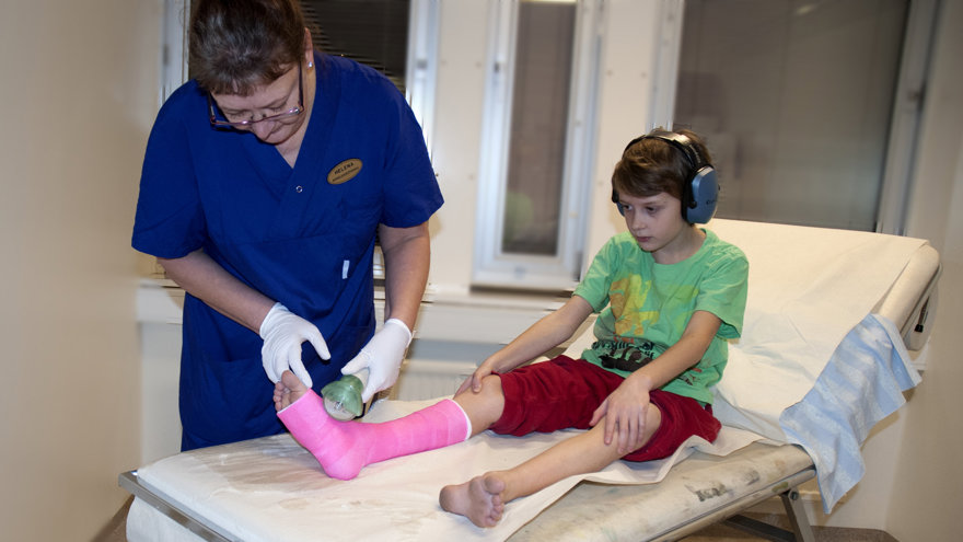 En sjukusköterska sågar gips