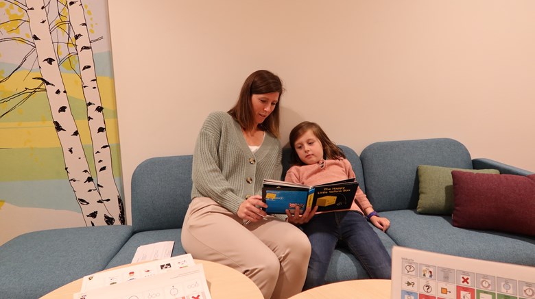 En vuxen och ett barn läser en bok