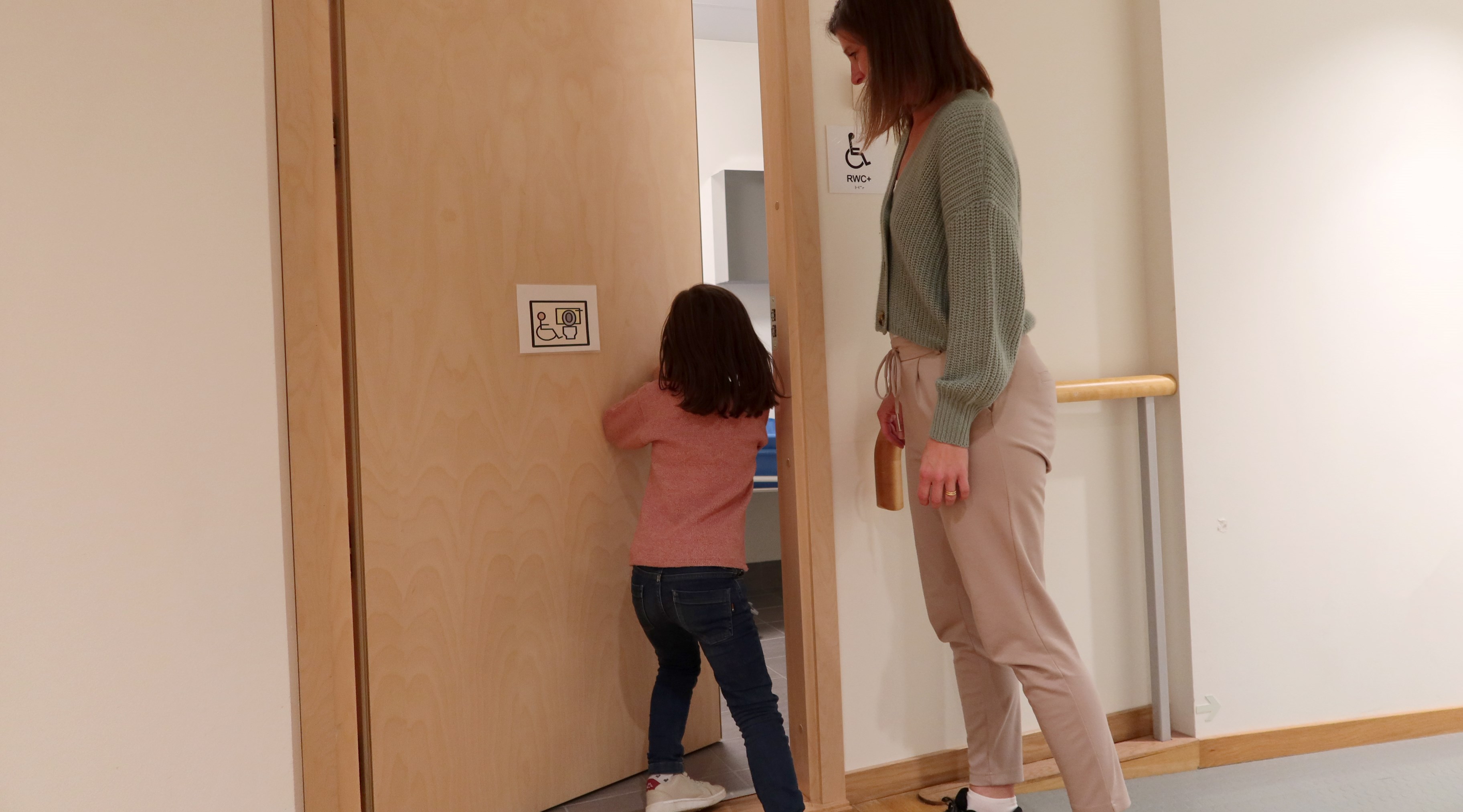 Ett  barn öppnar en toalettdörr