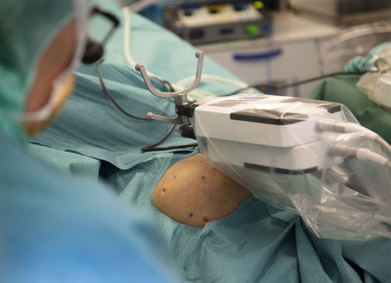 patient täckt av operationsdukar i bakgrund. kirurg i förgrund