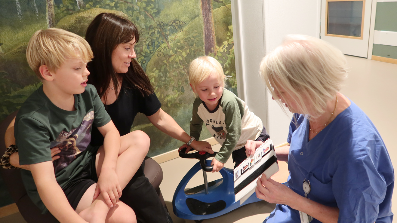 En famil i ett väntrum pekar tittar på ett bildstöd