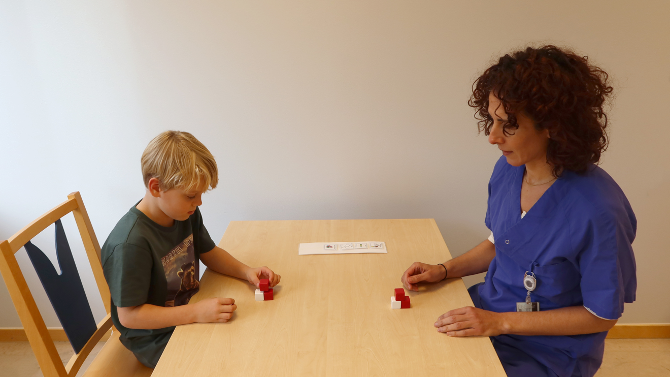 Ett barn staplar små klossar