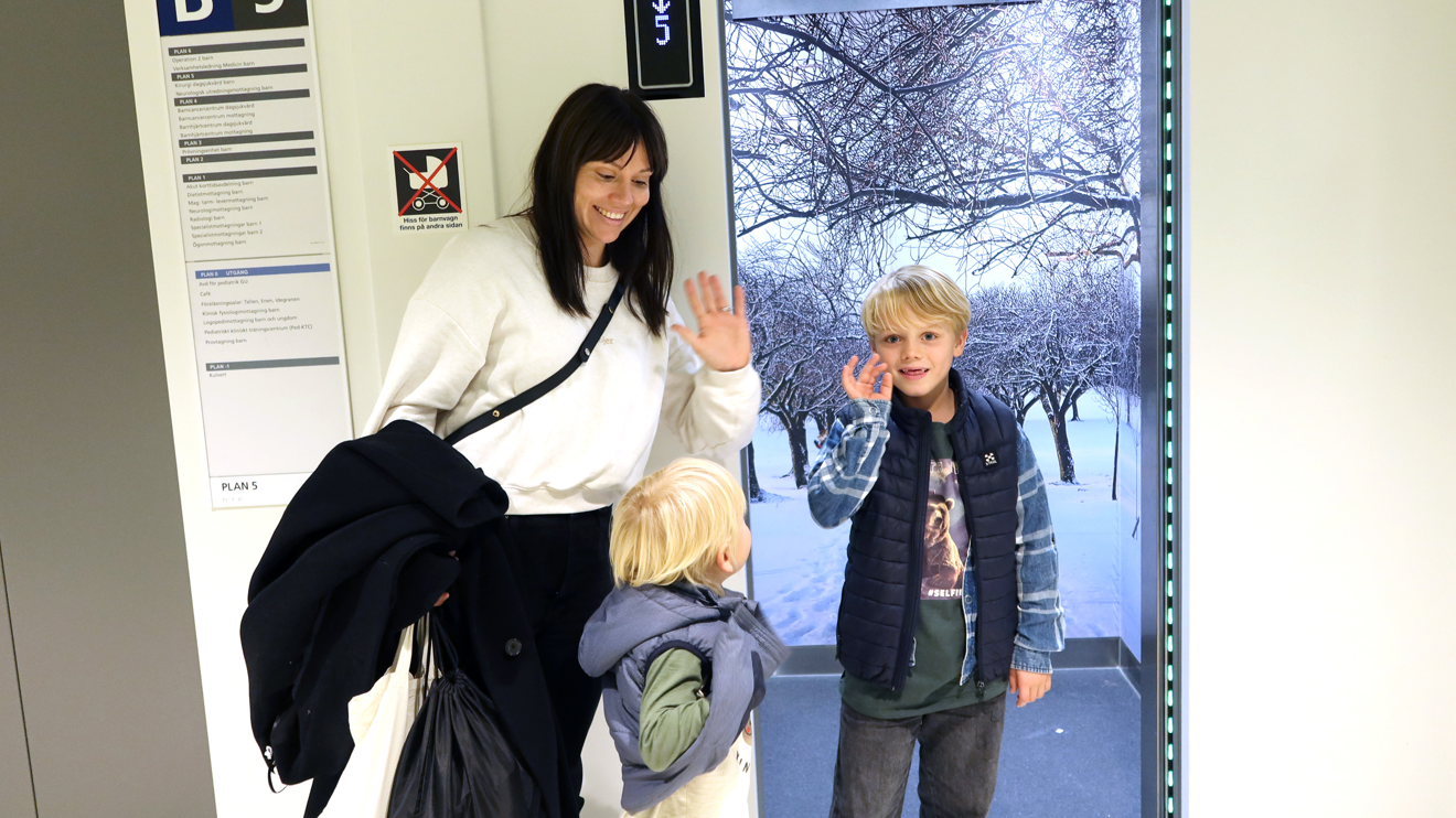 En familj vinkar hejdå vid hissen