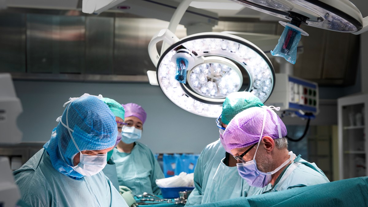 Surgeons in scrubs performing a surgery in an operating room