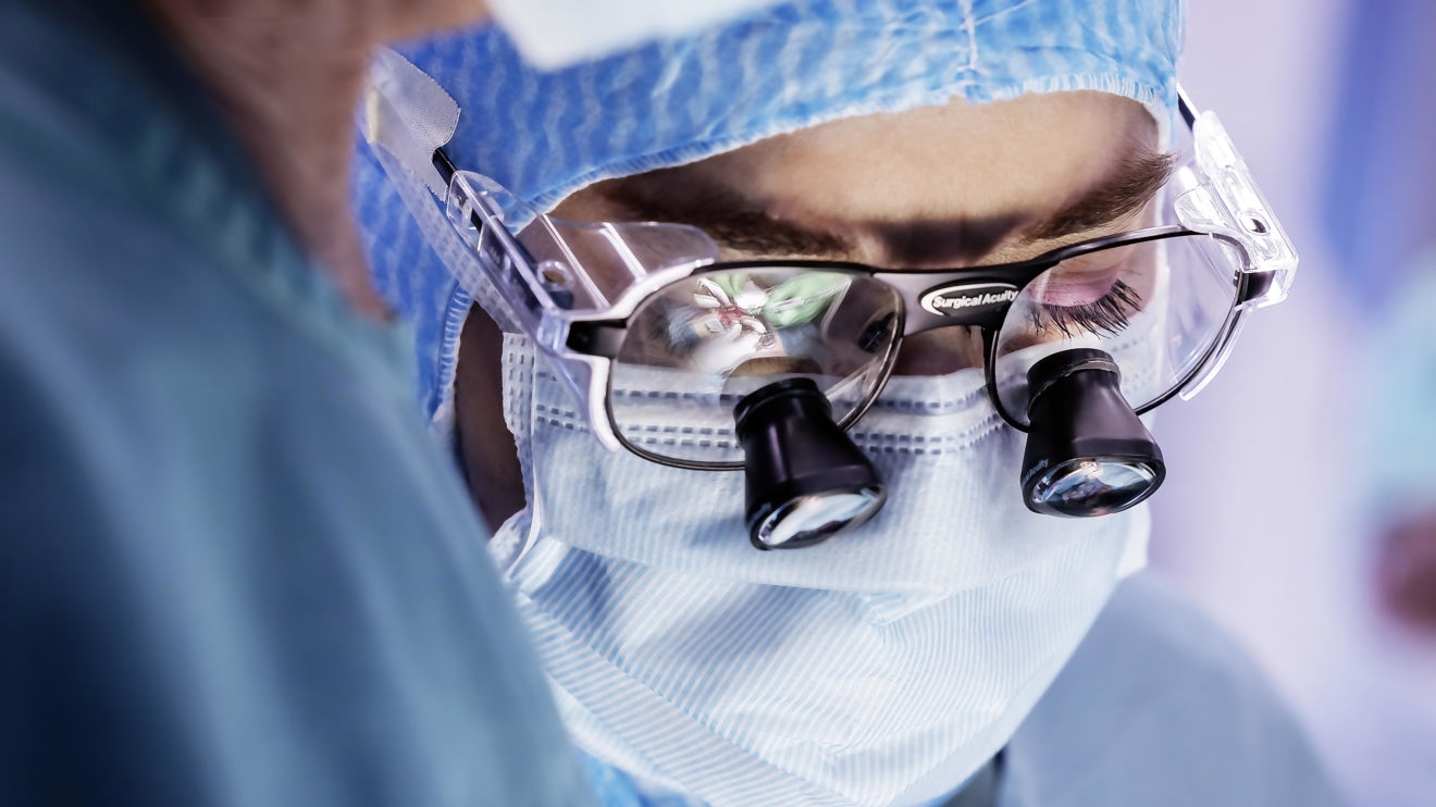 A doctor wearing magnifying glasses.