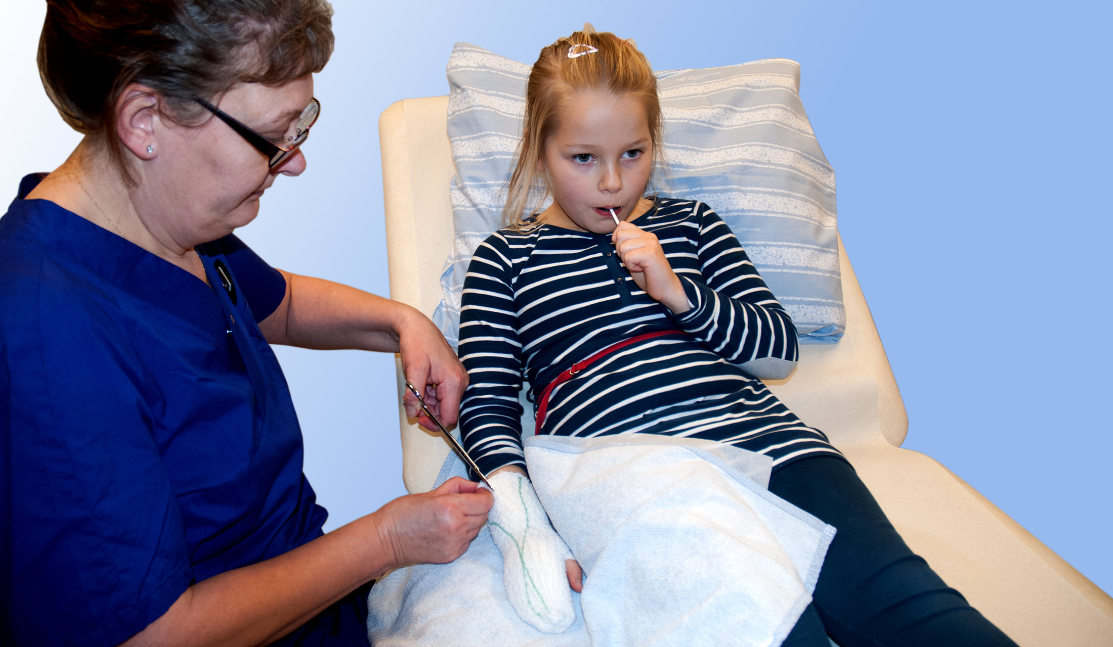 En sjuksköterska klipper upp bandage