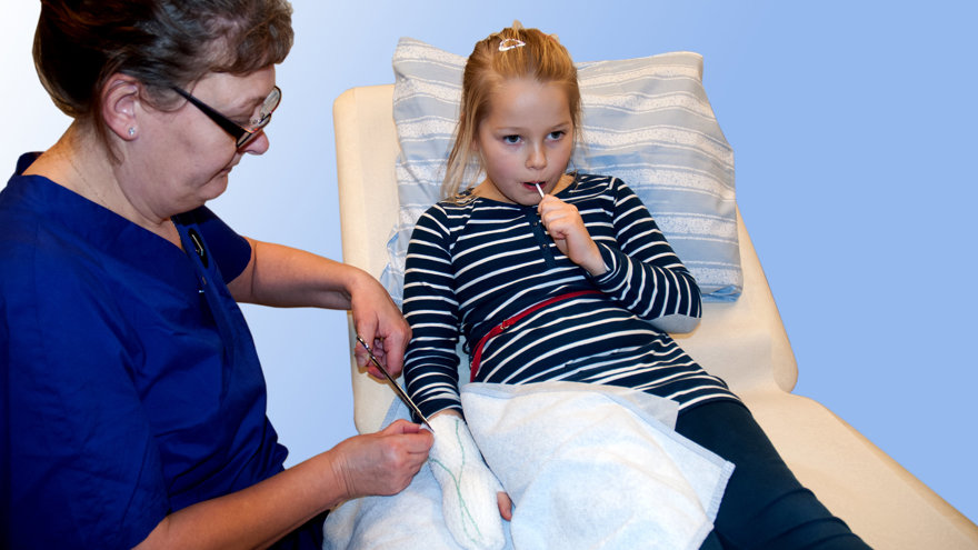 En sjuksköterska klipper upp bandage