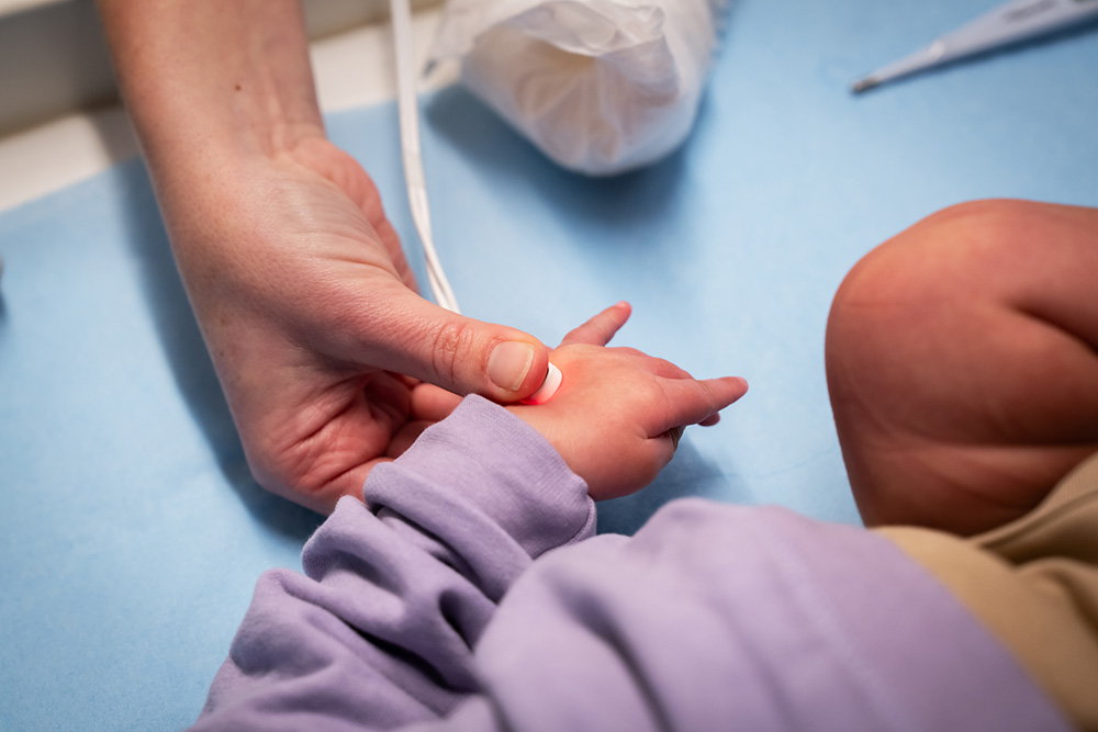 An adults hand holding a childs hand.