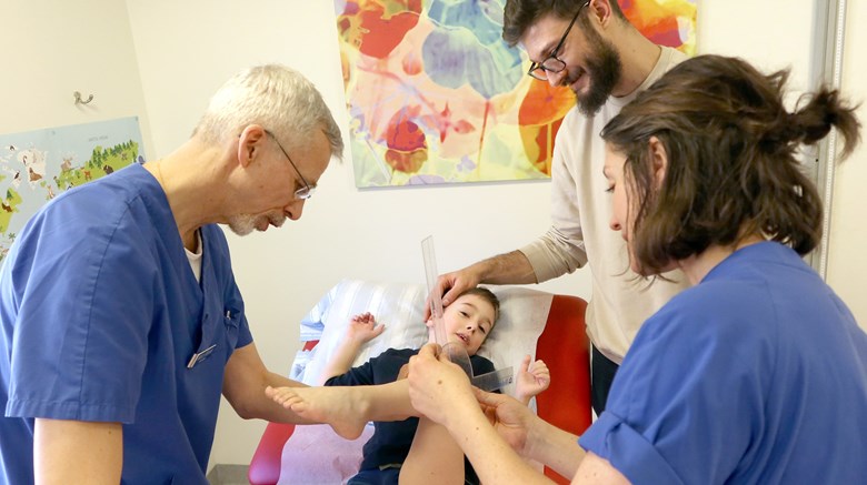 En fysioterapeut mäter knät på ett barn