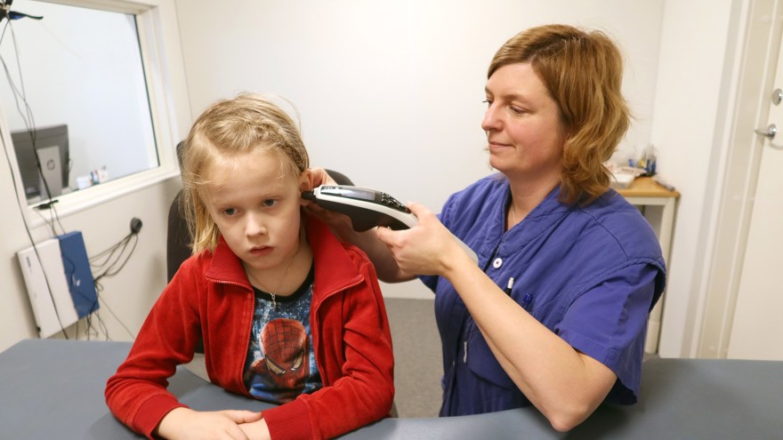 Ett barn har en apparat mot örat