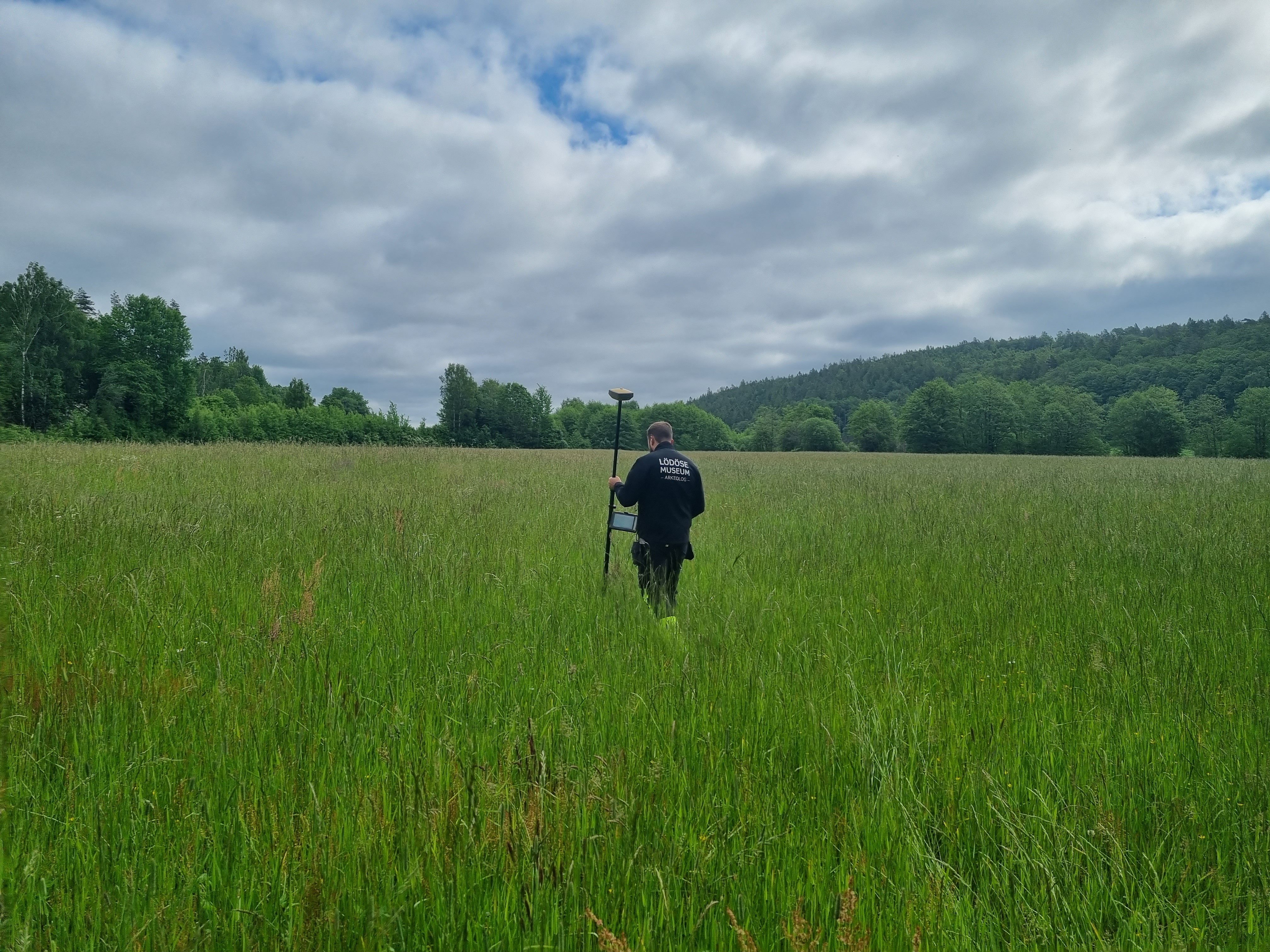En arkeolog ute på uppdrag i Marks kommun går på ett fält