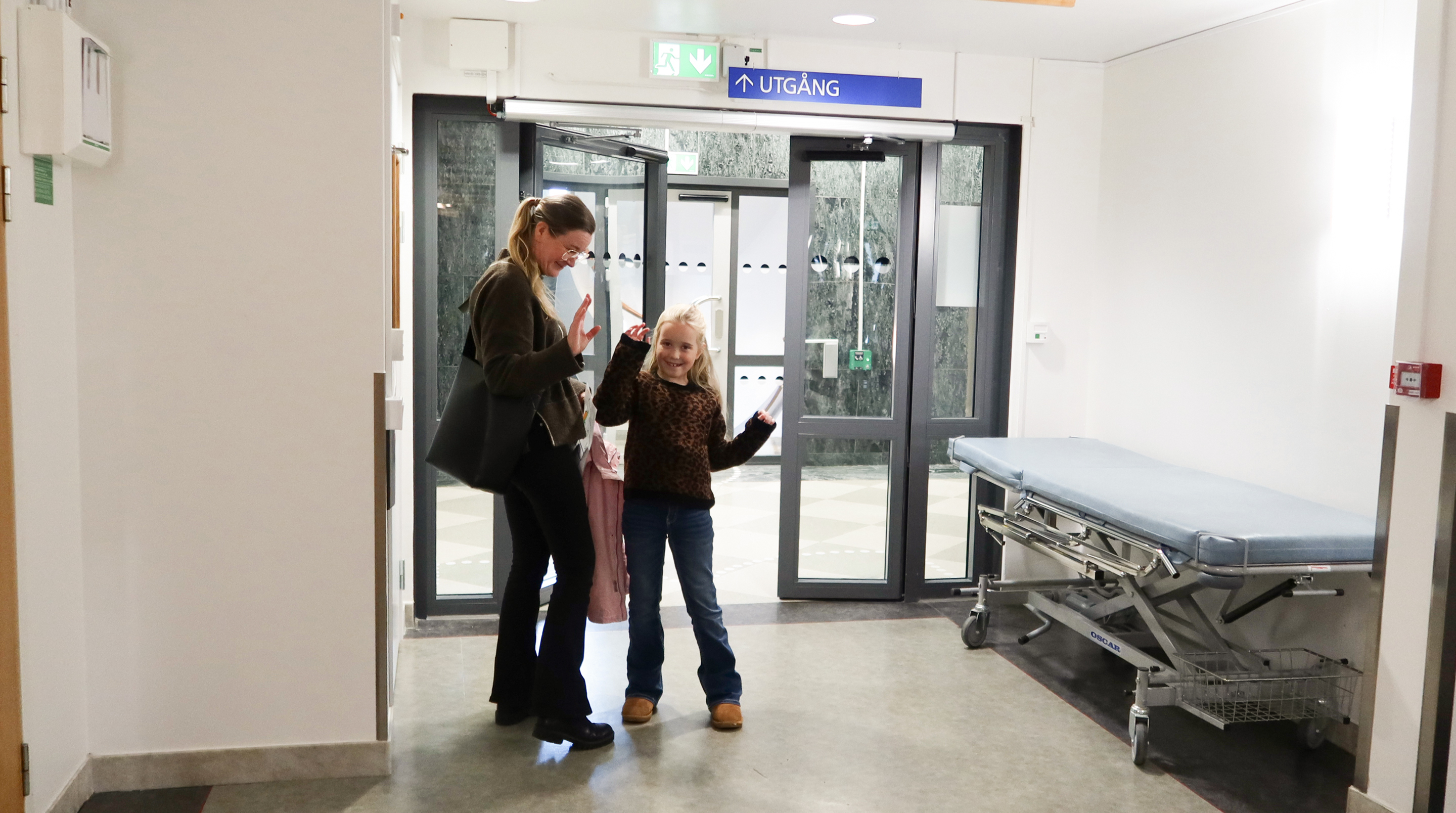 Ett barn och en mamma vinkar hejdå