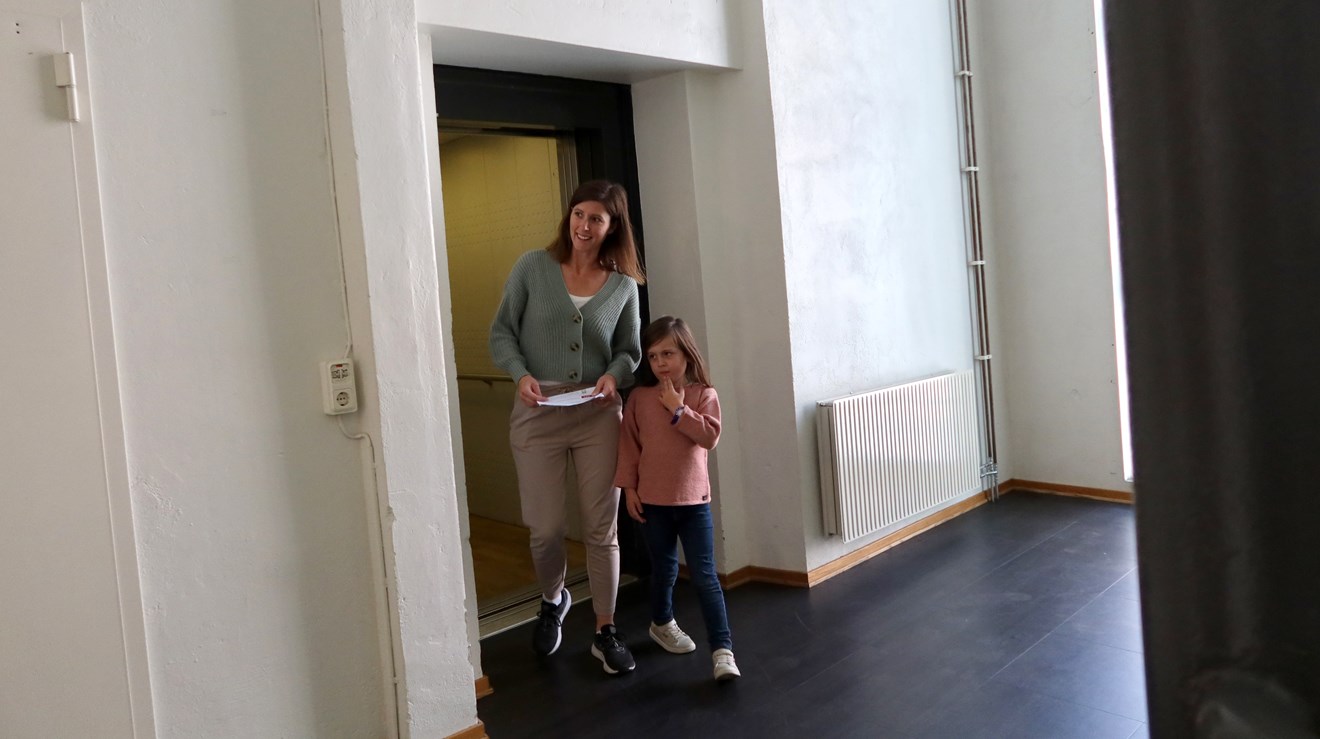 Ett  barn och en kvinna kommer ut ur en hiss