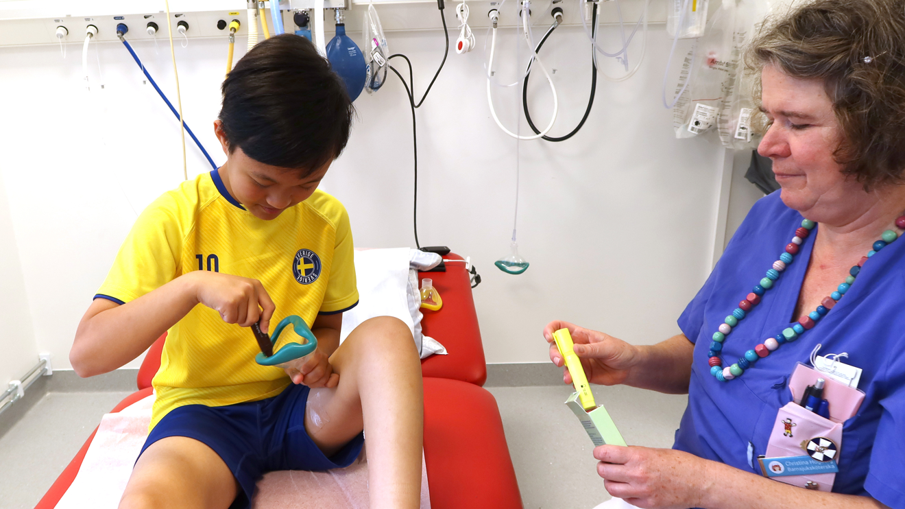 Ett barn målar med en smak-penna i en andningsmask