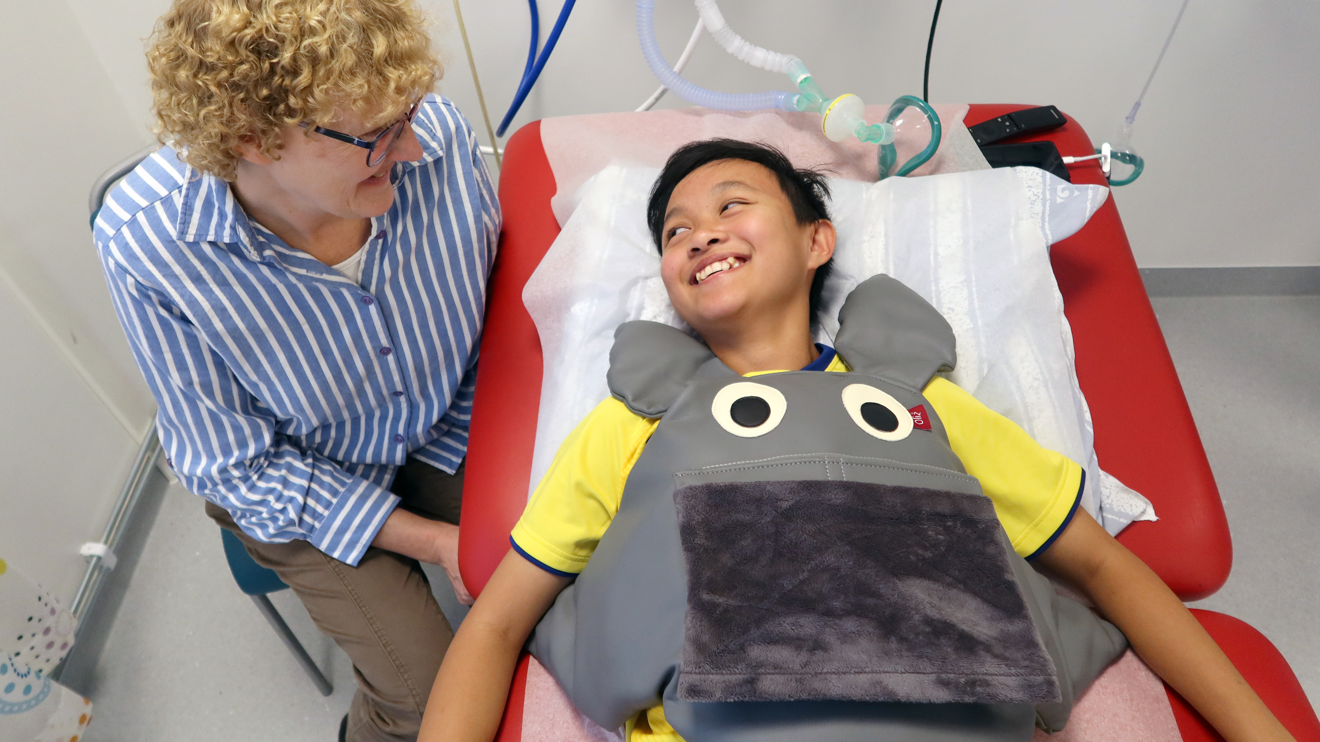 Ett barn har en tyngdkudde på sig