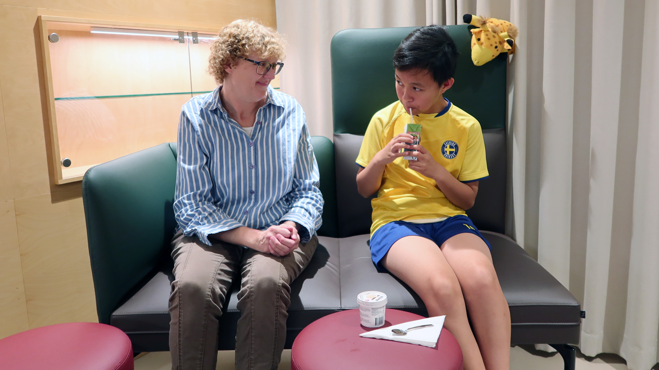 Ett barn som fikar i väntrummet