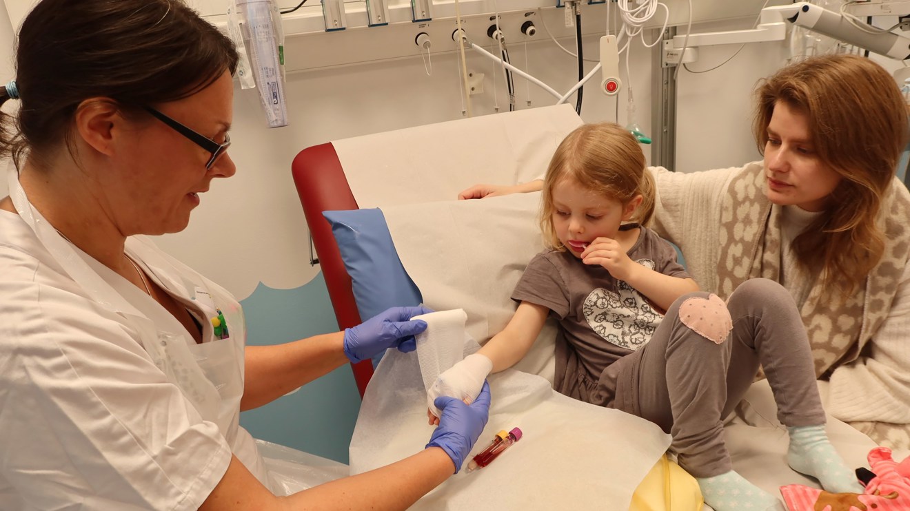 Ett barn får en linda runt handen